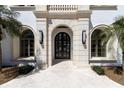 Grand entrance featuring a stone archway, dark wood double doors, and symmetrically placed plants at 14645 Isleview Dr, Winter Garden, FL 34787