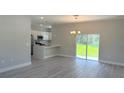 Bright and airy living room featuring a modern chandelier and an open layout to the kitchen at 15369 Sw 60Th Cir, Ocala, FL 34473