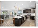 Bright open concept kitchen with stainless appliances, island seating, and view of living area at 2145 Rush Bay Way, Orlando, FL 32824