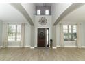 Elegant foyer featuring a soaring ceiling, wood floors, and decorative wall art at 2351 Kelbrook Ct, Oviedo, FL 32765