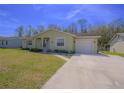 Charming single-story home featuring a well-maintained lawn, attached garage, and inviting facade at 260 La Paz Dr, Kissimmee, FL 34743