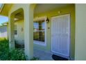 Close-up of a quaint front porch with decorative door, stylish light fixture and tiled floor at 260 La Paz Dr, Kissimmee, FL 34743