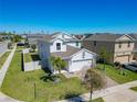 An aerial view of a suburban home with a brick driveway, green grass, and tropical palm trees at 2820 Black Birch Dr, Ocoee, FL 34761