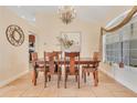 Elegant dining room with a wooden table, chandelier, and natural light from a large window at 30041 Redoak Ave, Eustis, FL 32736