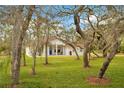 Quaint home framed by mature trees and a sprawling lawn, offering a serene setting at 30041 Redoak Ave, Eustis, FL 32736