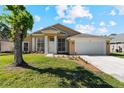 Charming single-story home featuring a well-manicured lawn, attached garage, and inviting entrance with bright sunshine at 3180 Town And Country Rd, Oviedo, FL 32766