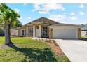 Charming single-story home featuring a well-manicured lawn, attached garage, and inviting entrance with bright sunshine at 3180 Town And Country Rd, Oviedo, FL 32766