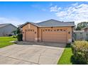 Three-car garage with traditional paneled doors and a concrete driveway, offering ample parking at 3710 Ahoya Ln, Orlando, FL 32837