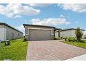 Lovely single-story home featuring a brick paver driveway, landscaping, and a well-manicured lawn at 4006 Copperleaf Ln, Poinciana, FL 34759