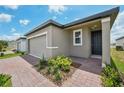 Attractive single-story home with paver driveway, green lawn, and appealing landscaping at 4006 Copperleaf Ln, Poinciana, FL 34759