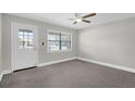 Bright bedroom with neutral walls, carpeted floor, ceiling fan, and a door to the outside at 4127 Sanseviera Ln, Orlando, FL 32822