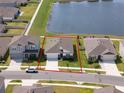 Aerial view of a home in a lakeside community, highlighted with a red property line at 447 Talisi Loop, St Cloud, FL 34771