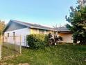 Side view of a single-story home featuring a chain-link fence and partial landscaping at 5622 Nokomis Cir, Orlando, FL 32839