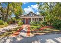 Beautifully landscaped front yard leads to this charming home with a welcoming red front door at 647 E Livingston St, Orlando, FL 32803