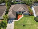 Aerial view of a single-story home with lush green lawn, landscaped front yard, and mature trees at 712 Timberwilde Ave, Winter Springs, FL 32708