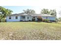 Charming light blue home with lush front lawn and well maintained landscaping at 7435 Redwing Rd, Groveland, FL 34736