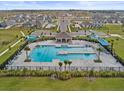 Aerial view of a community pool with a splash pad, lounge chairs, and ample parking at 800 Griffon Ave, Lake Alfred, FL 33850