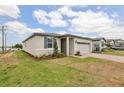 Stylish single-story home boasts a lush lawn, brick-paved driveway, and a two-car garage at 800 Griffon Ave, Lake Alfred, FL 33850