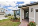 Inviting single-story home with manicured landscaping, brick walkway, and covered front entry at 800 Griffon Ave, Lake Alfred, FL 33850