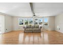 Open living room with laminate flooring, ceiling fan, and bright windows at 1028 Capella Dr, Tavares, FL 32778