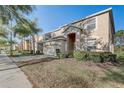 Charming two-story home featuring a two-car garage, arched entryway, and beautifully maintained lawn at 1028 Orange Cosmos Blvd, Davenport, FL 33837