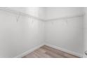 Walk-in closet with wood-look flooring and wire shelving at 11926 Verrazano Dr, Orlando, FL 32836