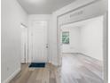 Bright entryway featuring wood-look floors, white walls, a white front door, and a glimpse into another room at 11926 Verrazano Dr, Orlando, FL 32836
