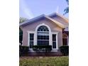 Charming home exterior featuring a large arch window, trimmed bushes, and well-maintained lawn at 12863 Holdenbury Ln, Windermere, FL 34786