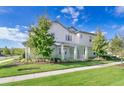 A bright and sunny two-story home with a covered porch and nicely trimmed landscaping at 13852 Maskawa Ave, Orlando, FL 32827