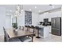 Modern kitchen featuring stainless steel appliances, a chalkboard menu, and stylish dining area at 1563 Sandbagger Dr, Davenport, FL 33896