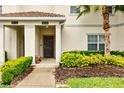 Close-up of a townhouse entrance showing a walkway, shrubs, and a covered entryway at 1570 Sandbagger Dr, Davenport, FL 33896