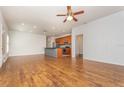 Open-concept living room with hardwood floors, ceiling fan, and view to the kitchen at 201 Walter Stevens Way, Deland, FL 32724