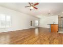 Open-concept living room featuring wood floors, lots of light, and a ceiling fan at 201 Walter Stevens Way, Deland, FL 32724