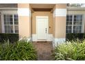 A welcoming front entrance with sidelight windows, brick walkway, and trimmed hedges creating curb appeal at 2545 Azzurra Ln, Ocoee, FL 34761