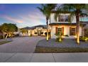 Beautiful two-story home showcasing a brick driveway and lush landscaping with palm trees at 2680 Lookout Ln, Kissimmee, FL 34746