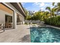 Backyard pool area with a built-in outdoor kitchen and patio seating with green foliage at 3322 Helen Ave, Orlando, FL 32804
