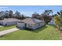 Single-story home with solar panels, a large lawn, and an attached garage at 355 Gardenia Ct, Kissimmee, FL 34759