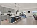 Open-concept kitchen with an island, stainless steel appliances, and adjacent dining area at 4180 Bull St, St Cloud, FL 34772