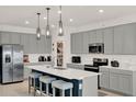 Modern kitchen with gray cabinets, a center island with seating, and stainless steel appliances at 4180 Bull St, St Cloud, FL 34772