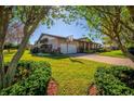 Well-maintained front yard with lush green grass, a basketball hoop, and a brick driveway leading to the garage at 5011 Dorian Ave, Belle Isle, FL 32812