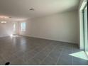 Bright living room with tile flooring and large windows providing plenty of natural light at 7028 Rolling Leaf Rd, Groveland, FL 34736