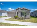 A well-maintained home featuring a neat front yard and a spacious driveway, set against a bright blue sky at 752 Trotters Dr, Eagle Lake, FL 33839