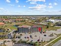 Wide aerial shot of a building with a parking lot, pond, and landscaping with a red indicator pinpointing an apartment at 831 Retreat Blvd # 103, Davenport, FL 33897