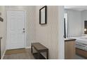 Entryway featuring a stylish bench with wallpaper and view of the bedroom at 831 Retreat Blvd # 103, Davenport, FL 33897