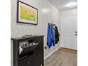 Inviting entryway featuring shoe storage, coat hooks, neutral wallpaper, and modern light gray flooring at 831 Retreat Blvd # 103, Davenport, FL 33897