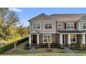 Two-story townhome with neat landscaping, a brick pathway, and neutral color palette at 10316 Spring Arbor Ln, Winter Garden, FL 34787