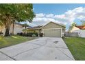 View of the well-maintained house showing an expansive driveway and some curb appeal at 1042 Catfish Creek Ct, Oviedo, FL 32765