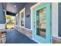 Inviting front porch with stone accents, a stylish blue door, and ample natural light at 11880 Sonnet Ave, Orlando, FL 32832