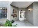 Inviting covered entryway featuring tiled flooring and lush landscaping around the windows at 139 Durham Pl, Longwood, FL 32779