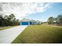 Inviting single-story home featuring a well-maintained lawn and blue-colored exterior at 1447 Kissimmee Way, Kissimmee, FL 34759